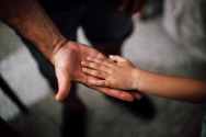 selective focus photography of child s hand on person s palm